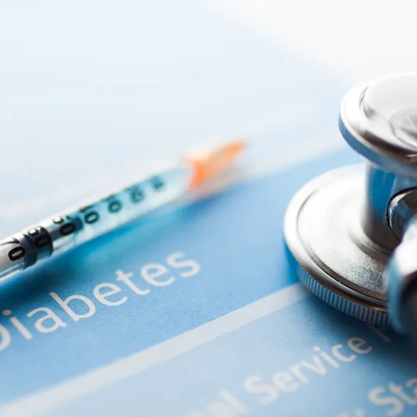 Diabetes and hearing loss concept with an insulin needle, physicians stethoscope, and medical documents about diabetes